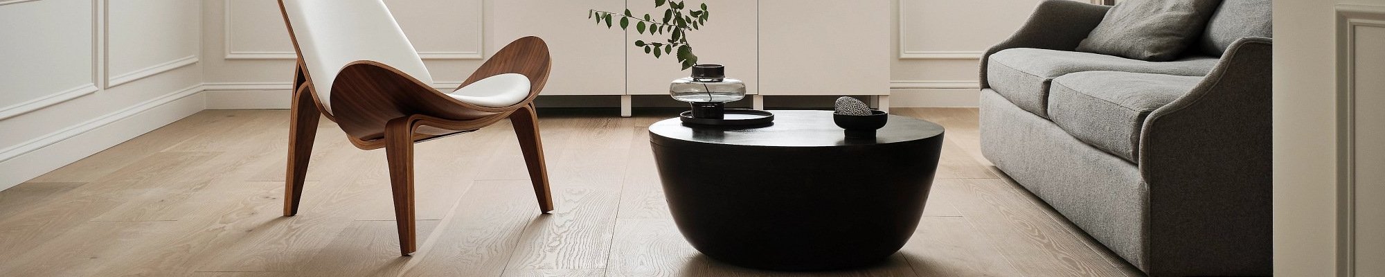 living room with hardwood floor and black coffee table with a plant on it in a glass vase from Perge Carpet & Floors in Wheaton, MD